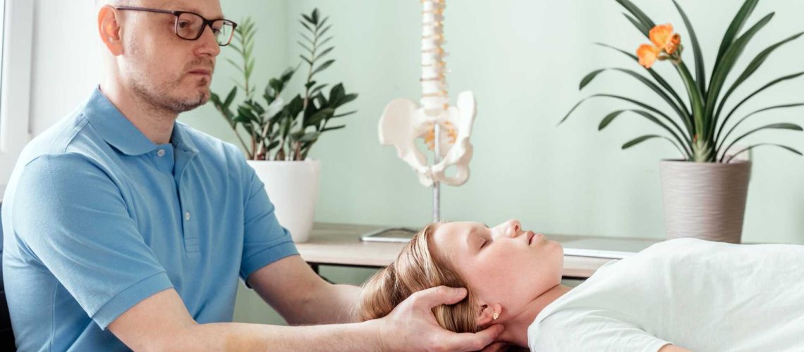 A therapist using osteopathic techniques to treat a girl.